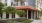 a building with a walkway and trees