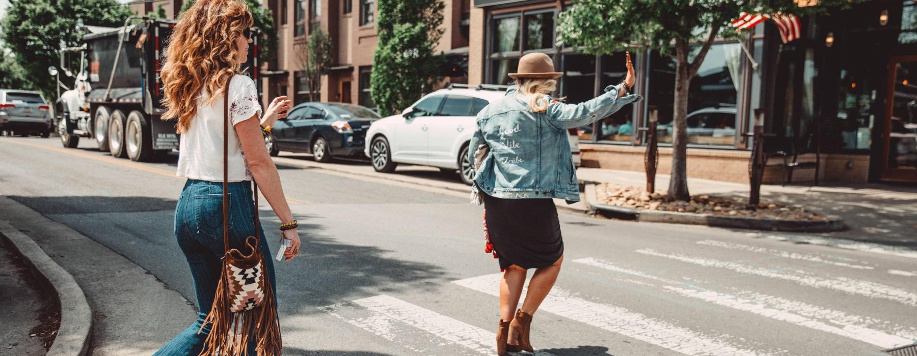 two people crossing a street