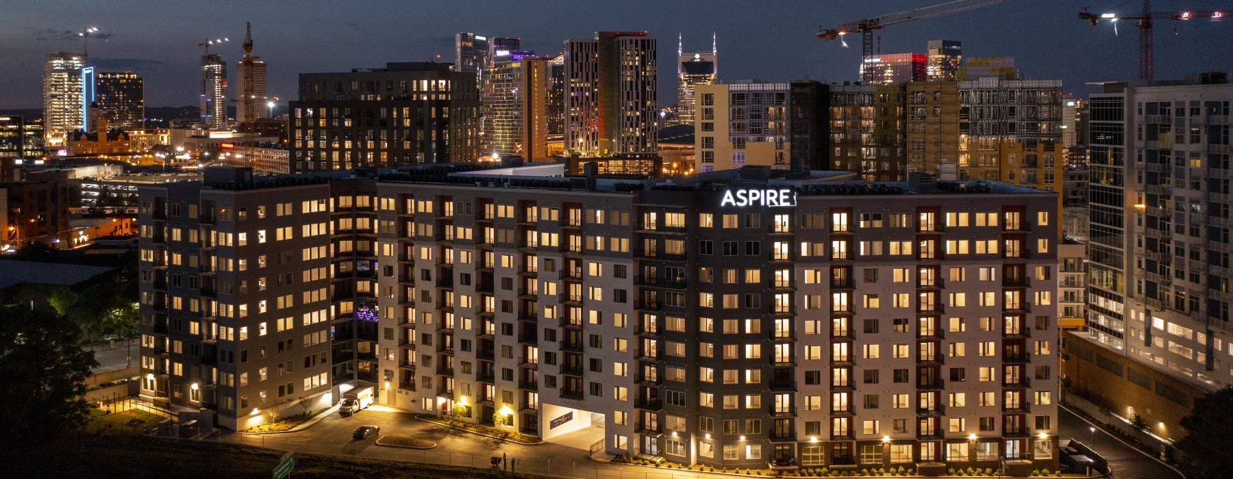 a large building with a city in the background at night